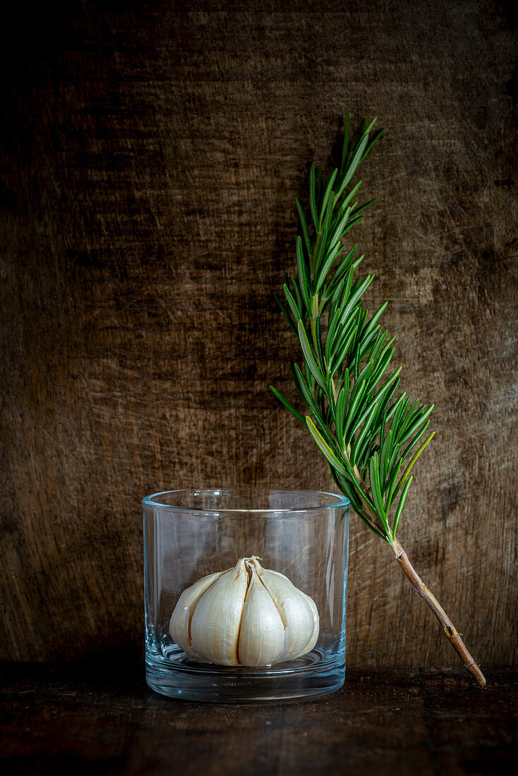 Knoblauchknolle im Glas mit Rosmarin