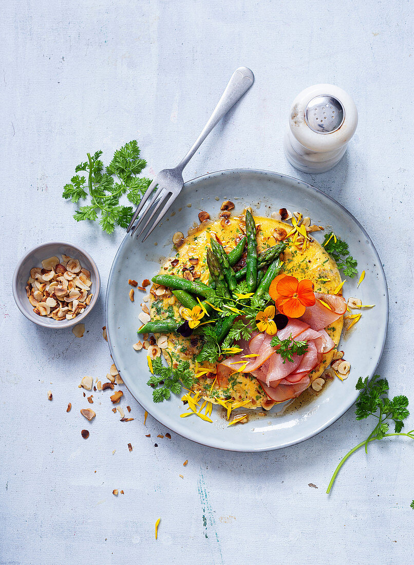 A nut omelette with green asparagus and ham