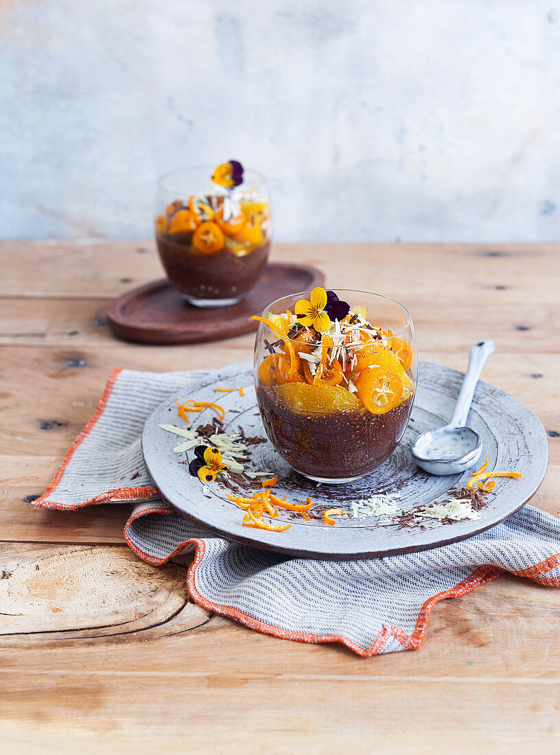 Chocolate chia pudding with kumquats, grated chocolate and edible flowers