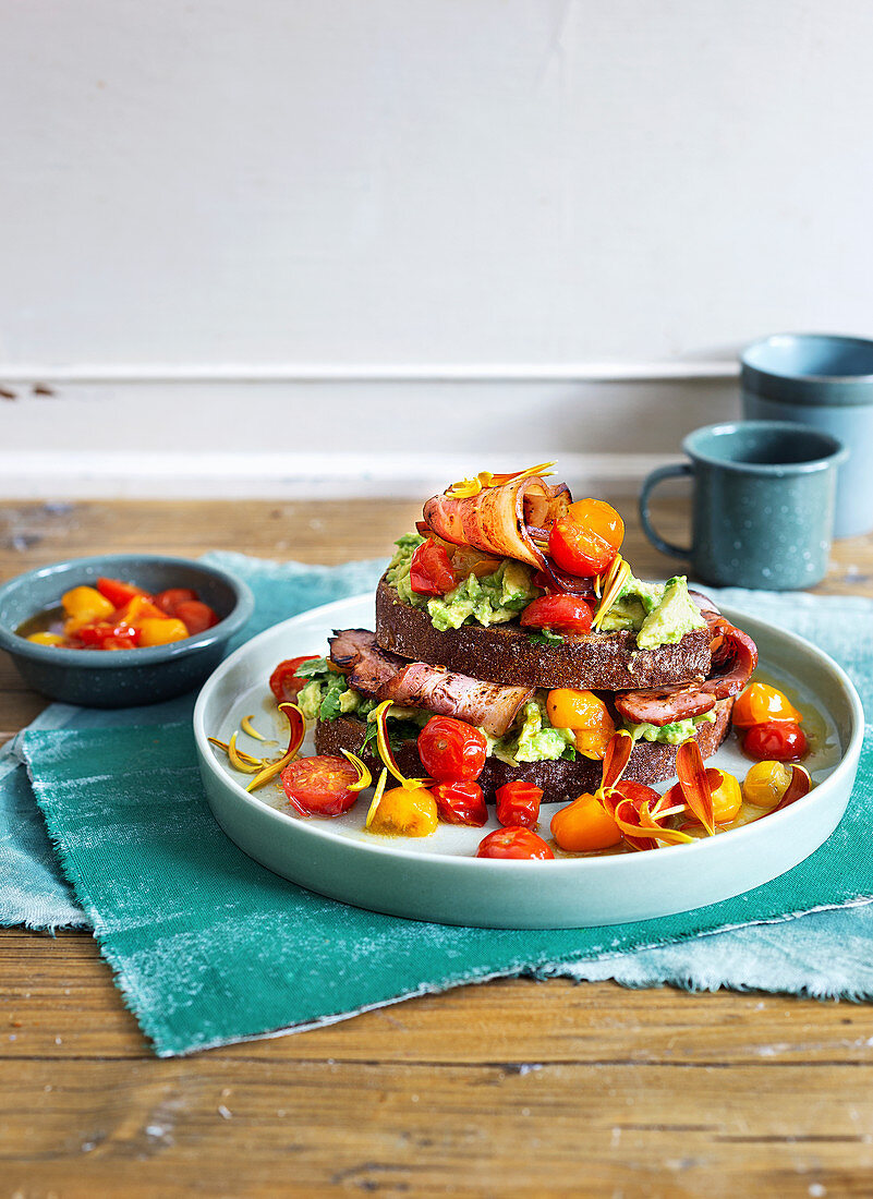 A sandwich with honey bacon, avocado cream and cherry tomatoes