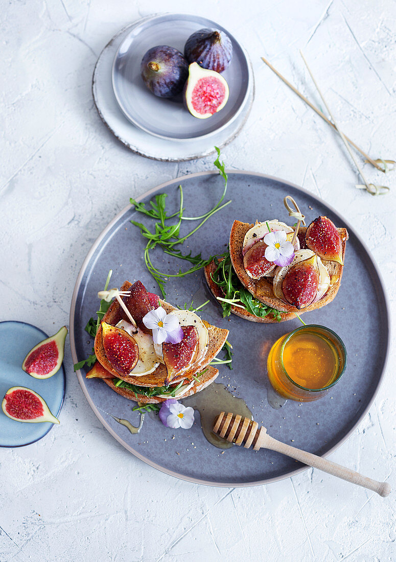 A goat's cheese sandwich with figs, honey and rocket