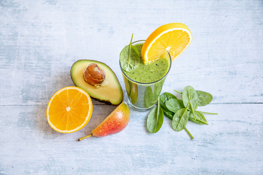 A green smoothie with avocado, spinach, orange and pears