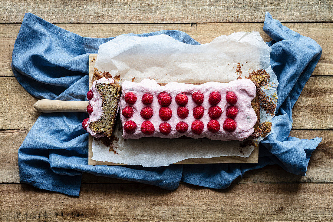 Sweet homemade cake topped with whipped cream and garnished with fresh raspberries