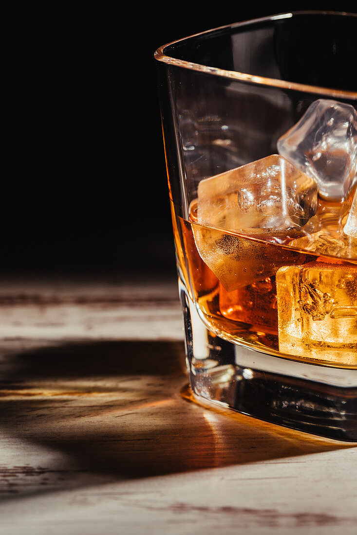 Glas Scotch mit Eiswürfeln auf rustikalem Holztisch