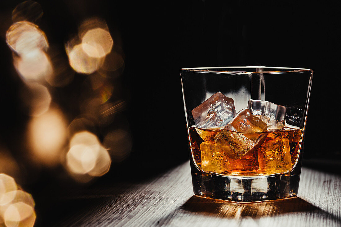 Glas Scotch mit Eiswürfeln auf rustikalem Holztisch