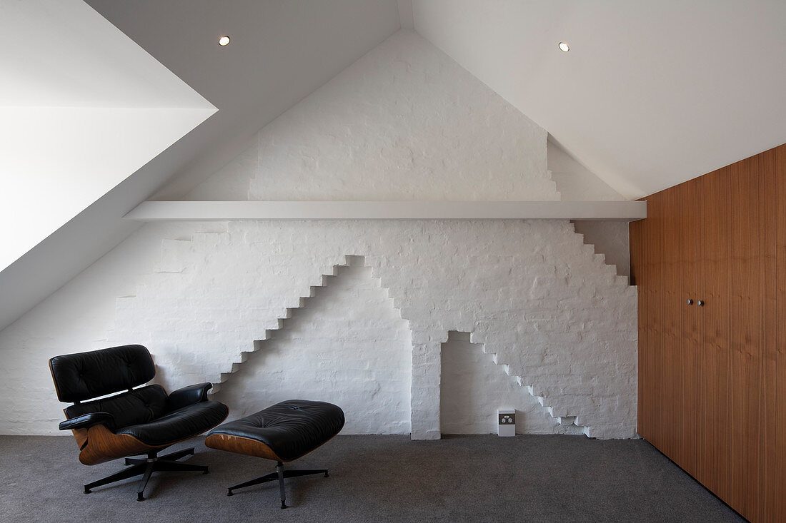 Eames Lounge Chair in front of white brick wall in attic room