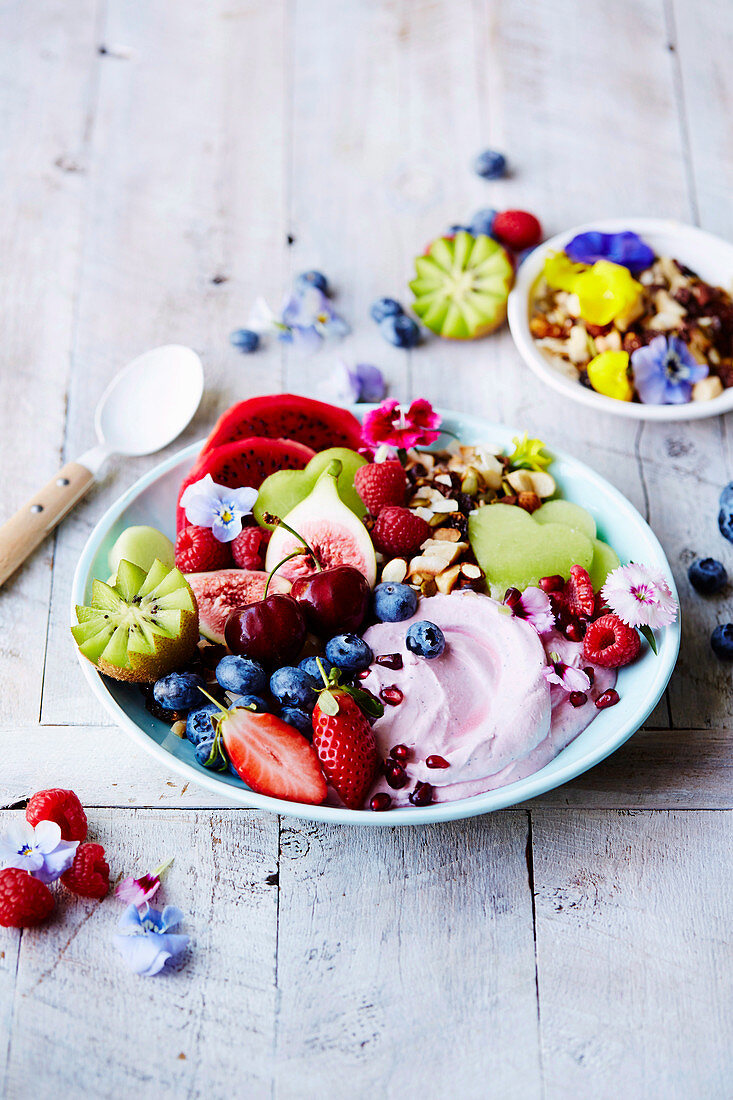 Crunch bowl with fresh fruits, berries and vegan yoghurt