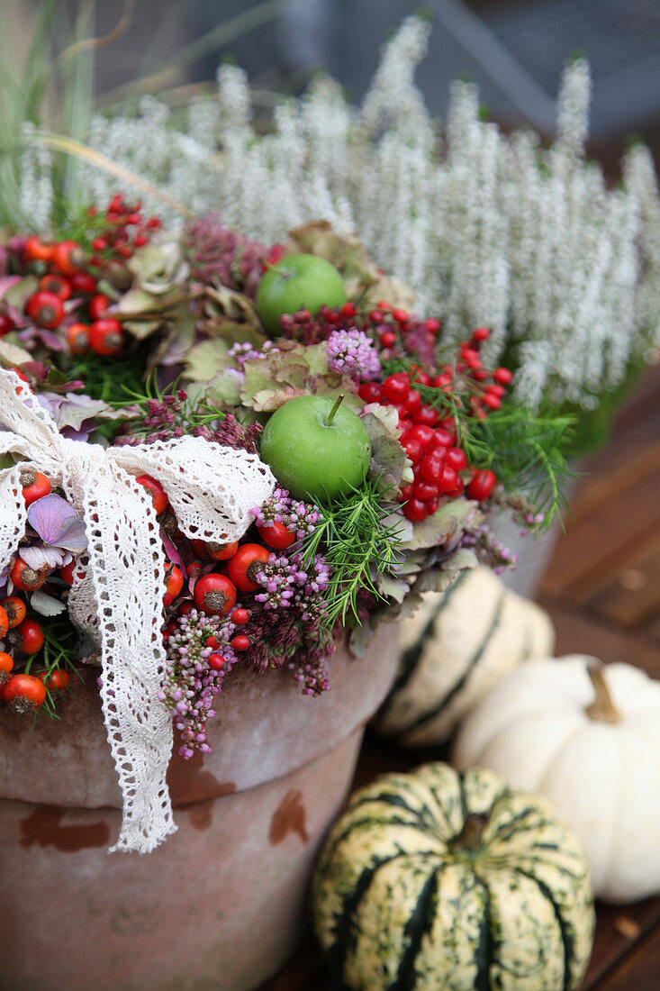 Autumn wreath with heather, rose hips, apples, hydrangea flowers, and viburnum cranberries