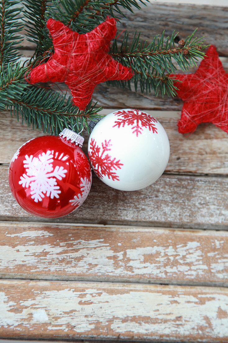 Christmas-tree baubles and sisal stars on spruce branch