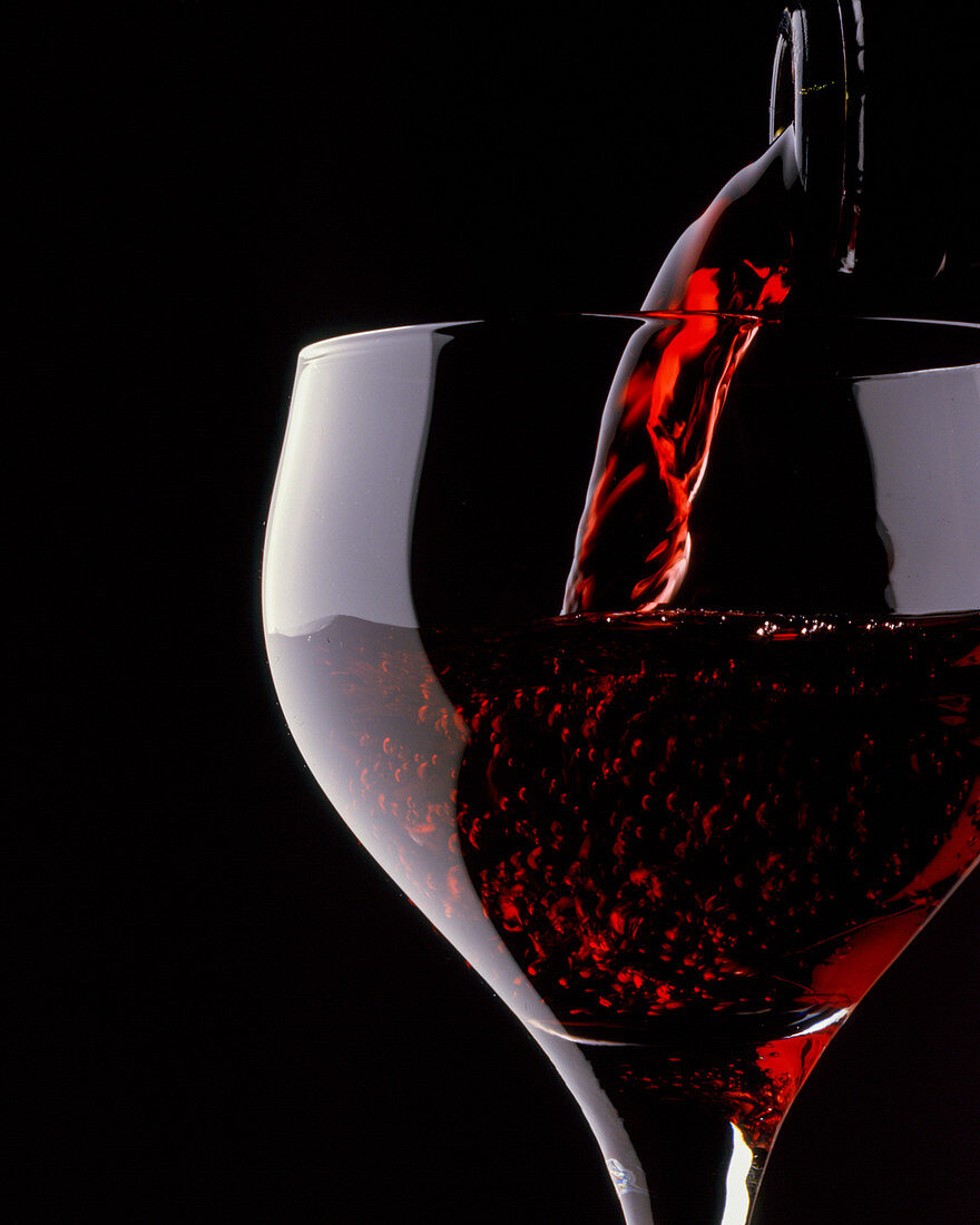 Rotwein wird in Weinglas gegossen