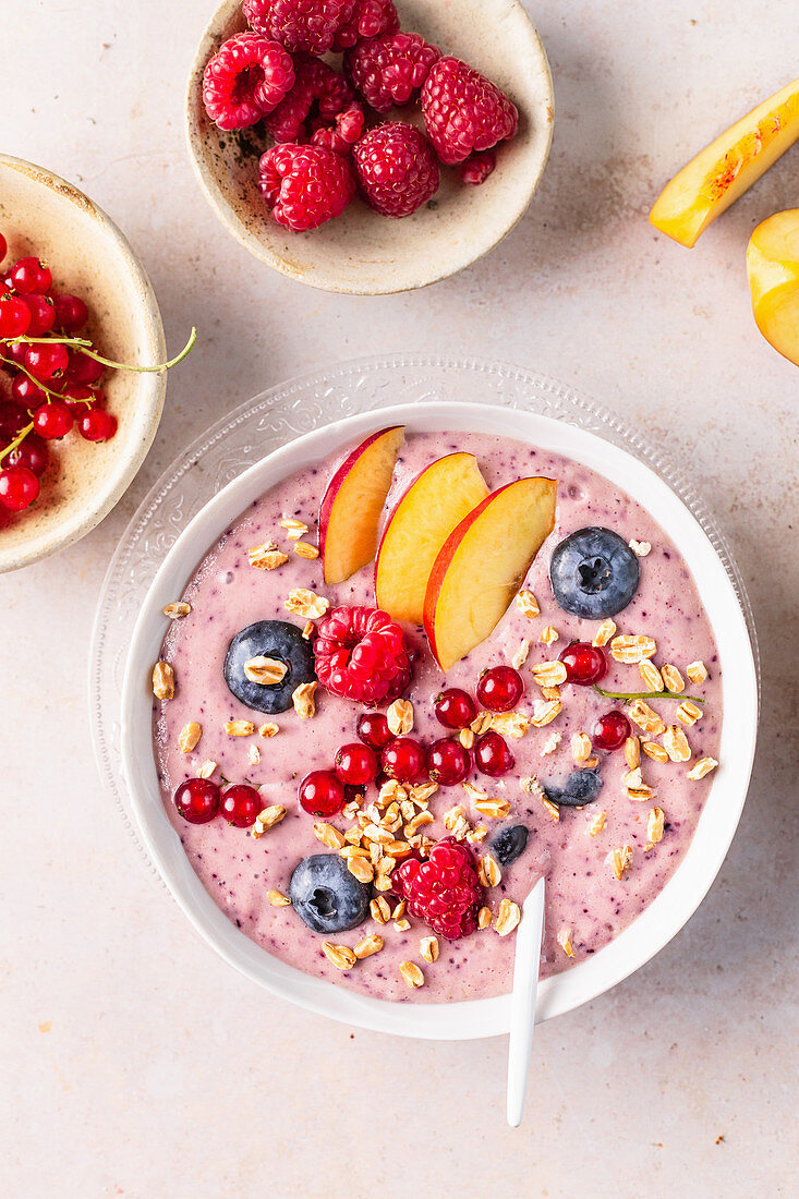 Rosa Smoothie-Bowl mit Früchten und Haferflocken