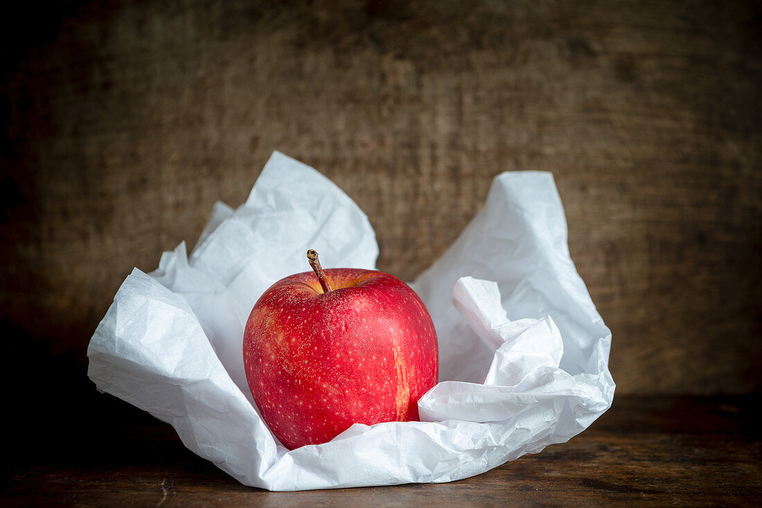 Ein Apfel auf weißem Seidenpapier