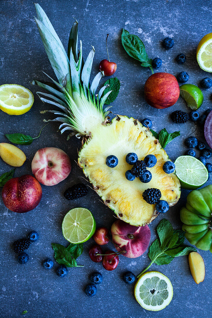 Rainbow of fruit, vegetables and herbs on a blue surface