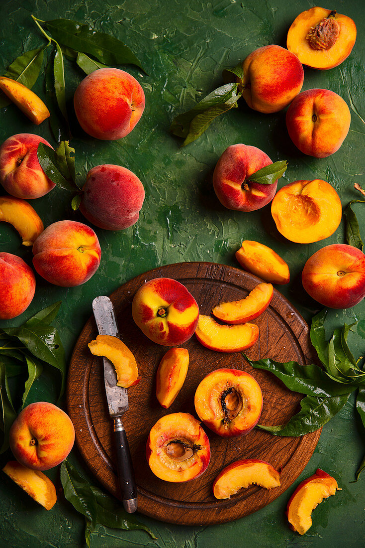 Fresh peaches with leaves on a wooden board
