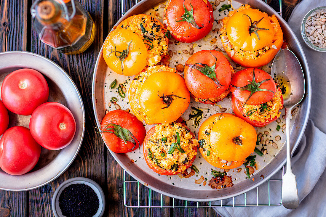 Rote und gelbe Tomaten gefüllt mit Couscous und Feta