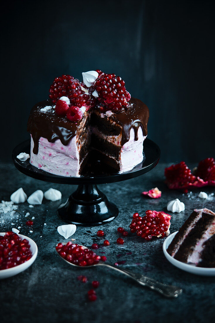 Slice of raspberry cake with chocolate meringues and pomegranate for Christmas