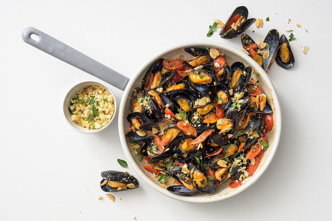 Fried mussels with cherry tomatoes and herb and almond crumbles