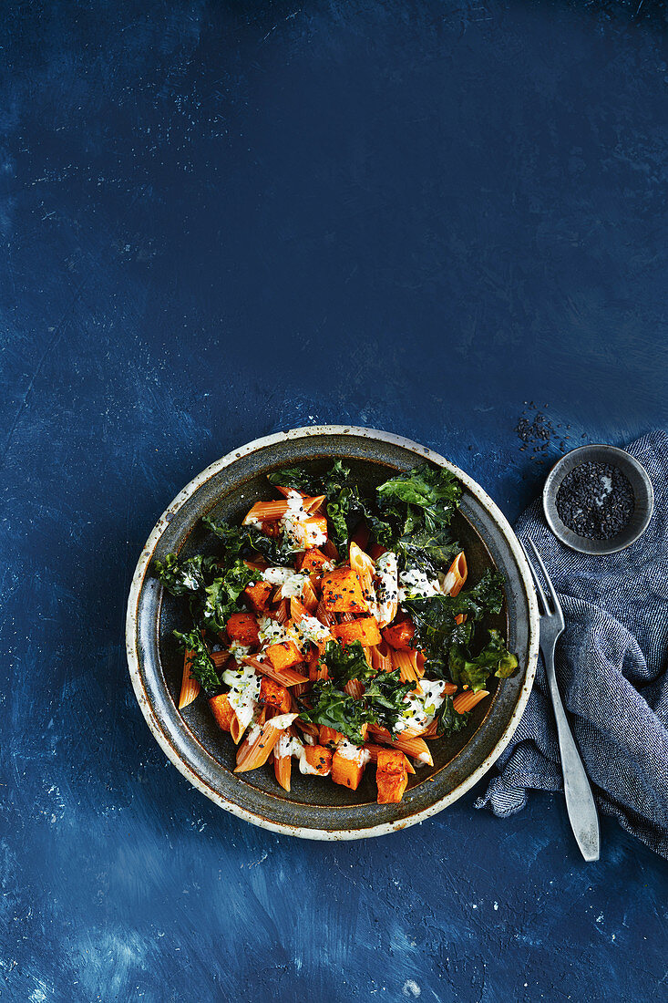 Warm red lentil penne salad with chilli pumpkin and tahini dressing