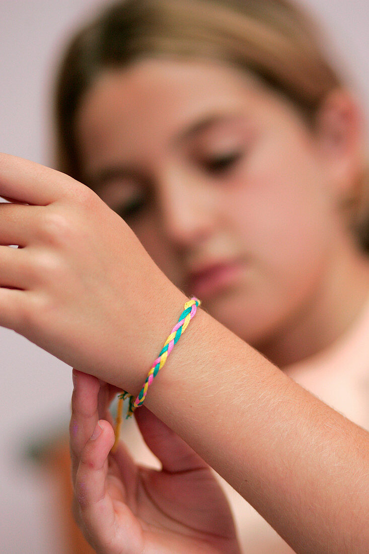 Girl tying friendship bracelet