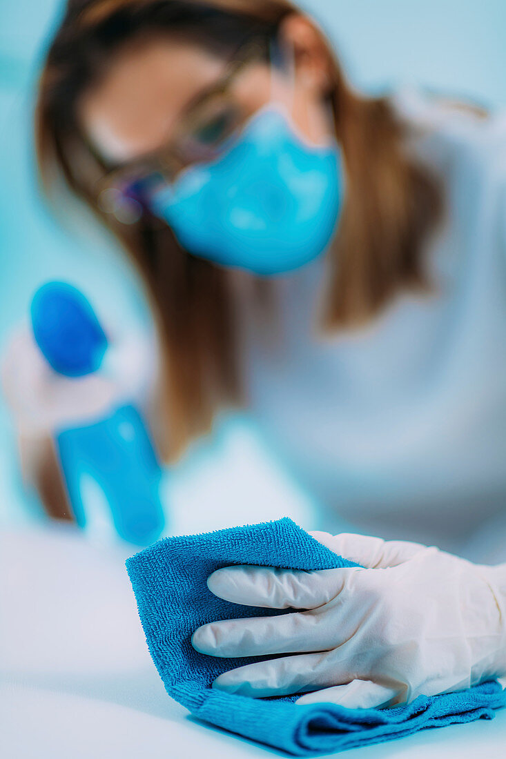 Woman disinfecting surface