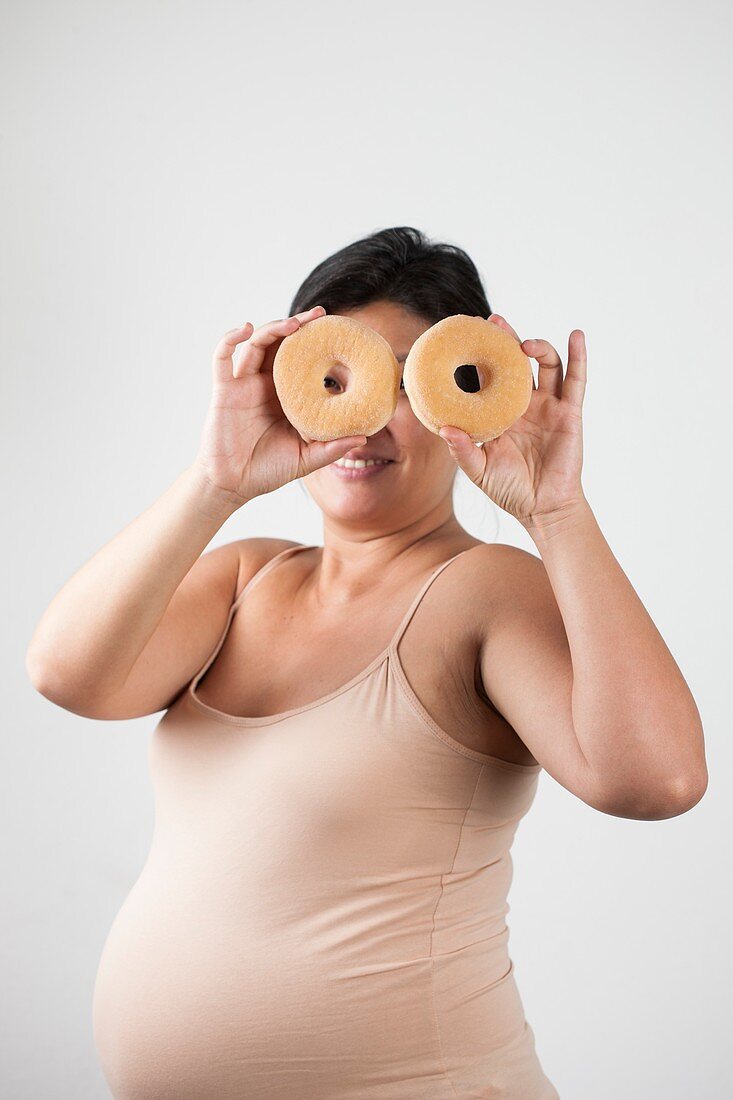 Pregnant woman holding doughnuts