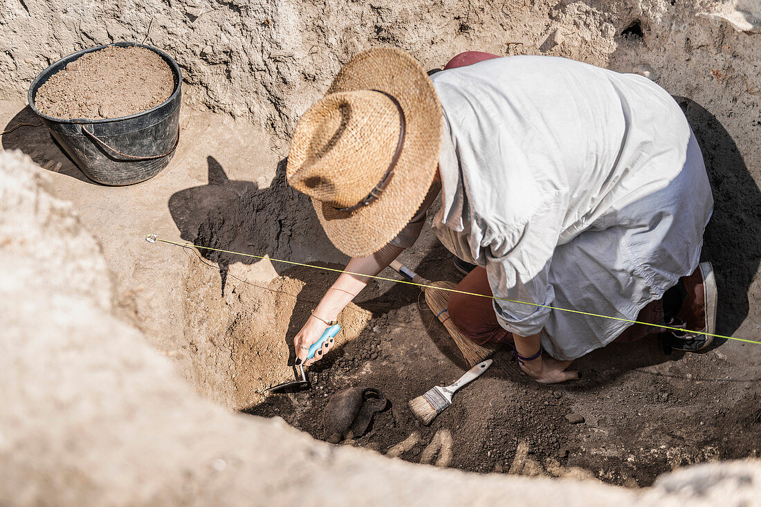 Archaeologist uncovering artefacts