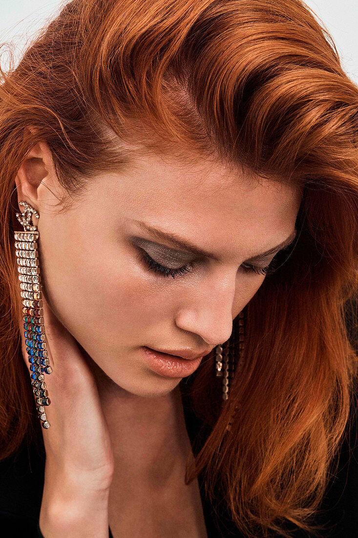 A red-haired woman wearing earrings