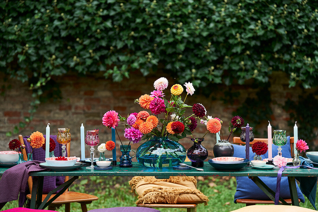 Festlich gedeckter Tisch mit Dahlienblüten dekoriert, im Freien
