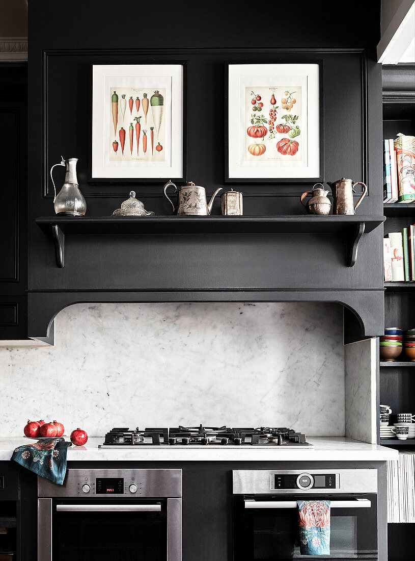 Vintage drawing and silver on black shelf above gas stove