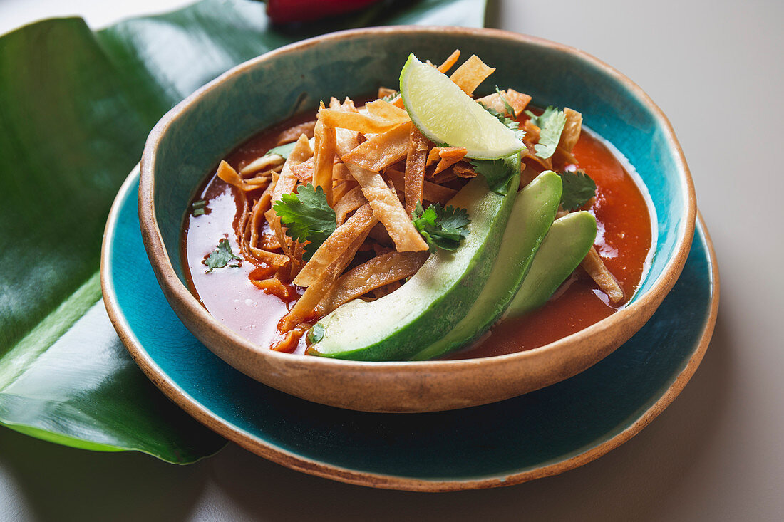 Azteken-Suppe (Suppe mit gebratenen Tortillastreifen und Avocado, Mexiko)