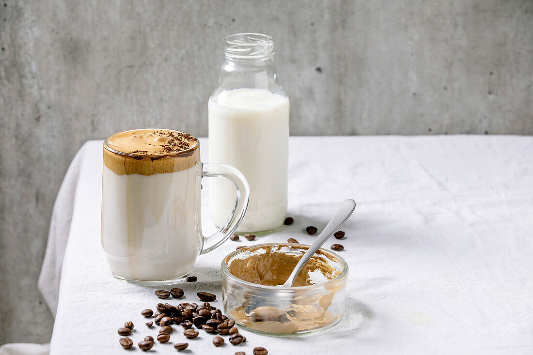 Dalgona Coffee (aufgeschlagener Instantkaffee) mit Zutaten auf Tisch