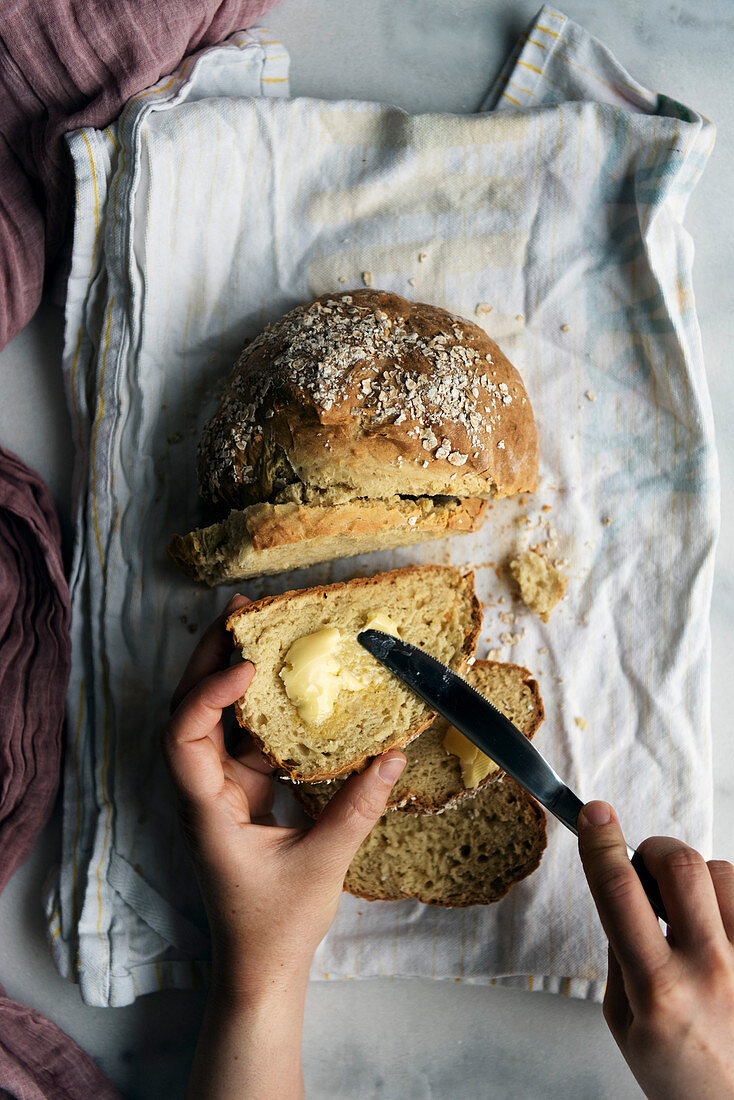 Woman spreading butter on a slice of homemade soda bread