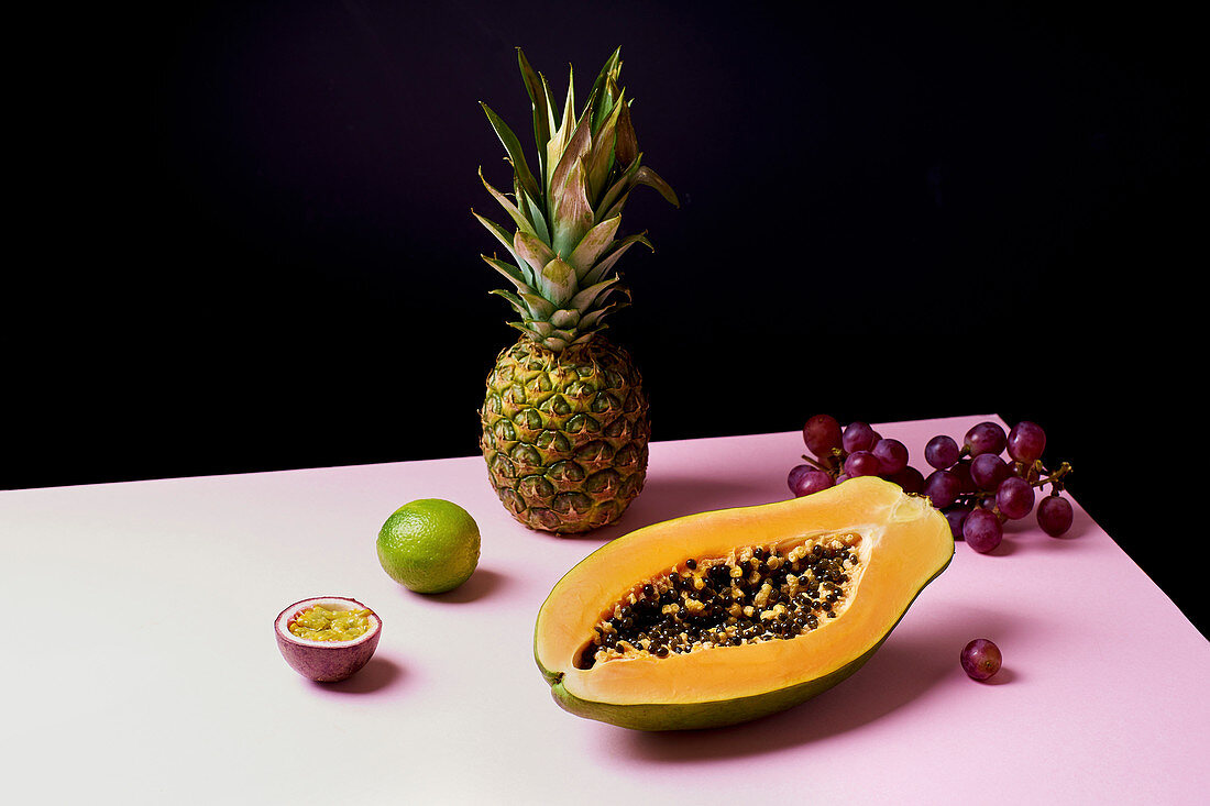 Tropical fruits still life with mango, papaya, pitahaya, passion fruit, grapes, lime and pineapple