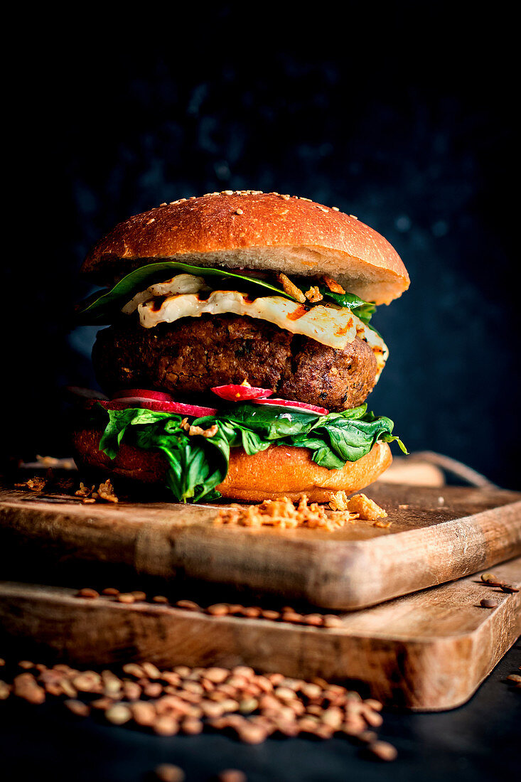 Lentils vegan hamburgers placed on wooden board on dark background