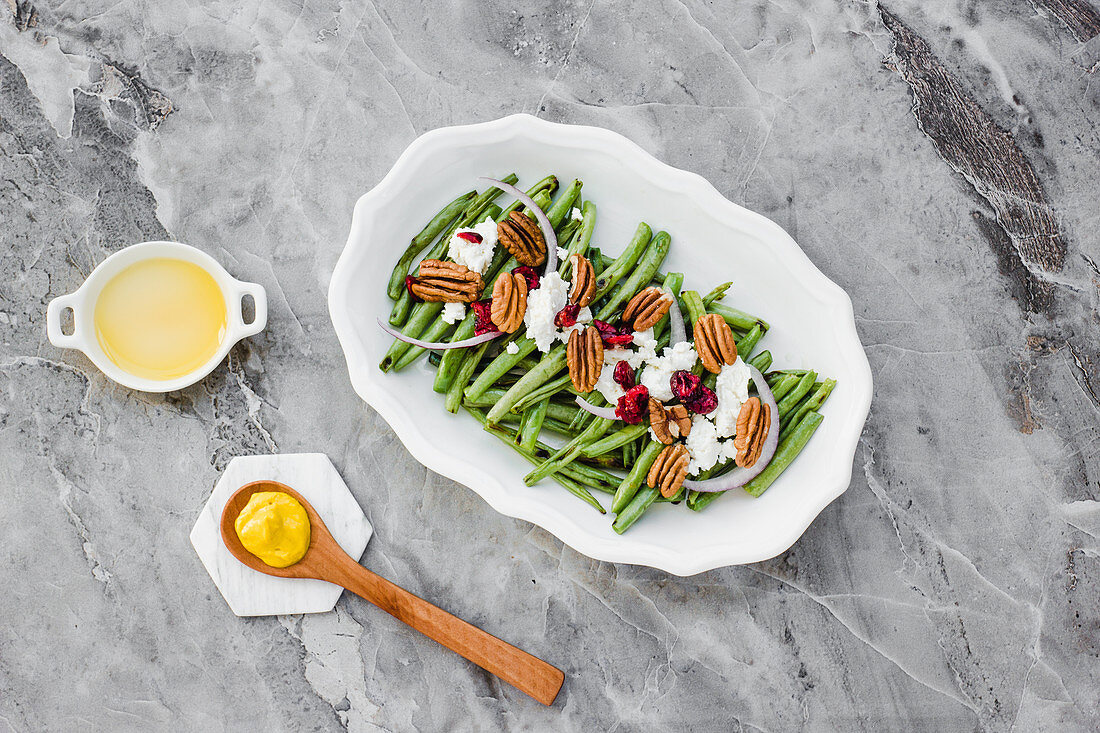 Salad with green beans and nuts on marble table