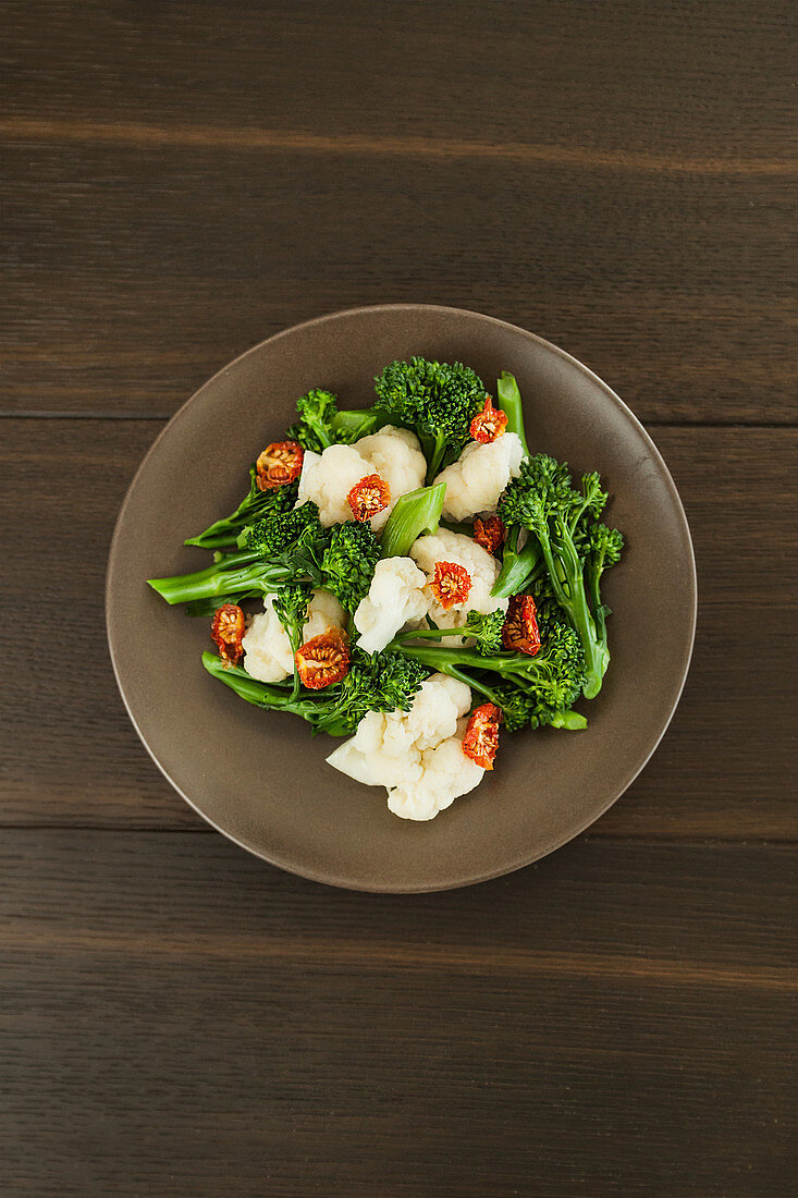 Fresh green broccolini and white cheese with chopped dried tomatoes