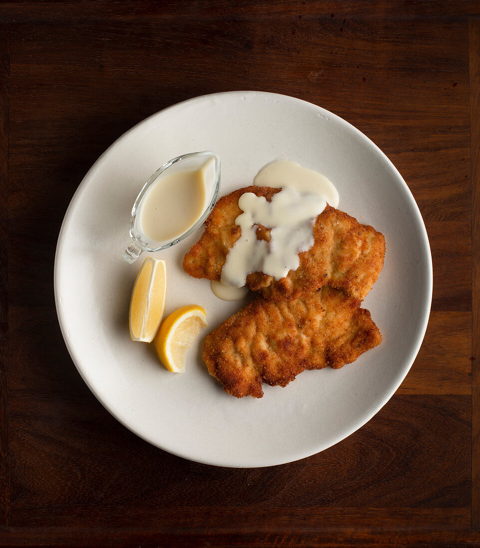 Paniertes Hähnchenschnitzel mit weißer Sauce