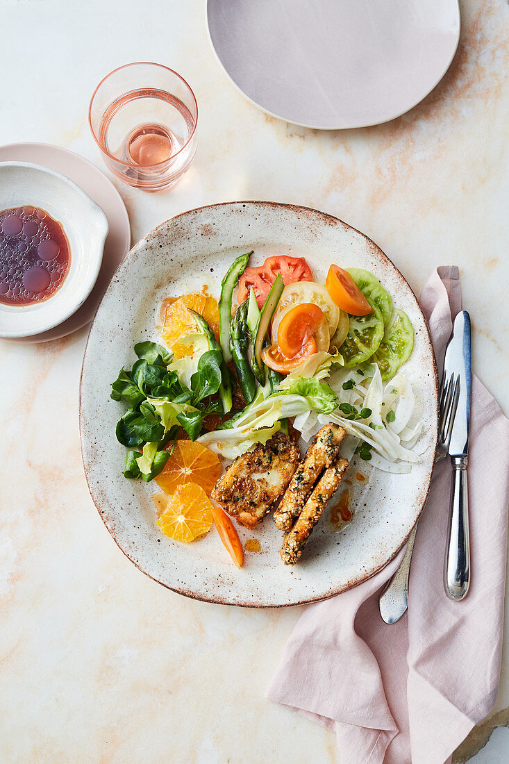 Lamb's lettuce salad with green asparagus, tomatoes, oranges and halloumi