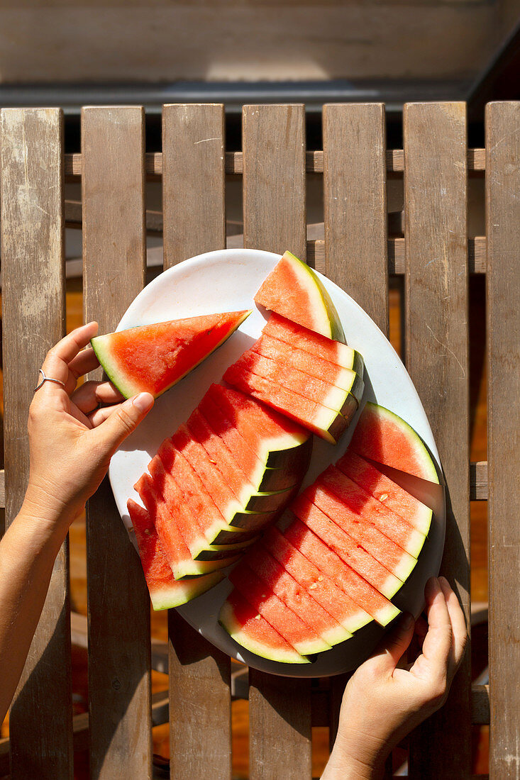 Wassermelone in Stücke geschnitten auf Gartentisch im Freien