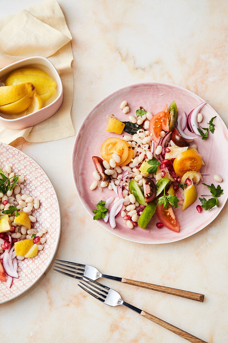 White beans with tomatoes, pomegranate seeds and salted lemons