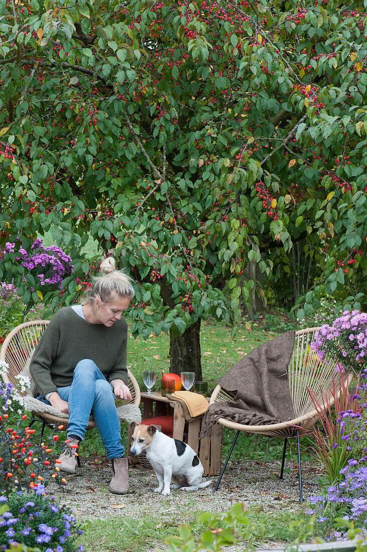 Kleine Sitzgruppe mit Frau und Hund Zula vor Zierapfelbaum