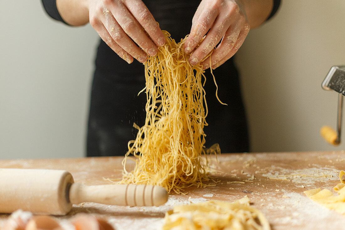 Cutting thin strips of pasta in hands