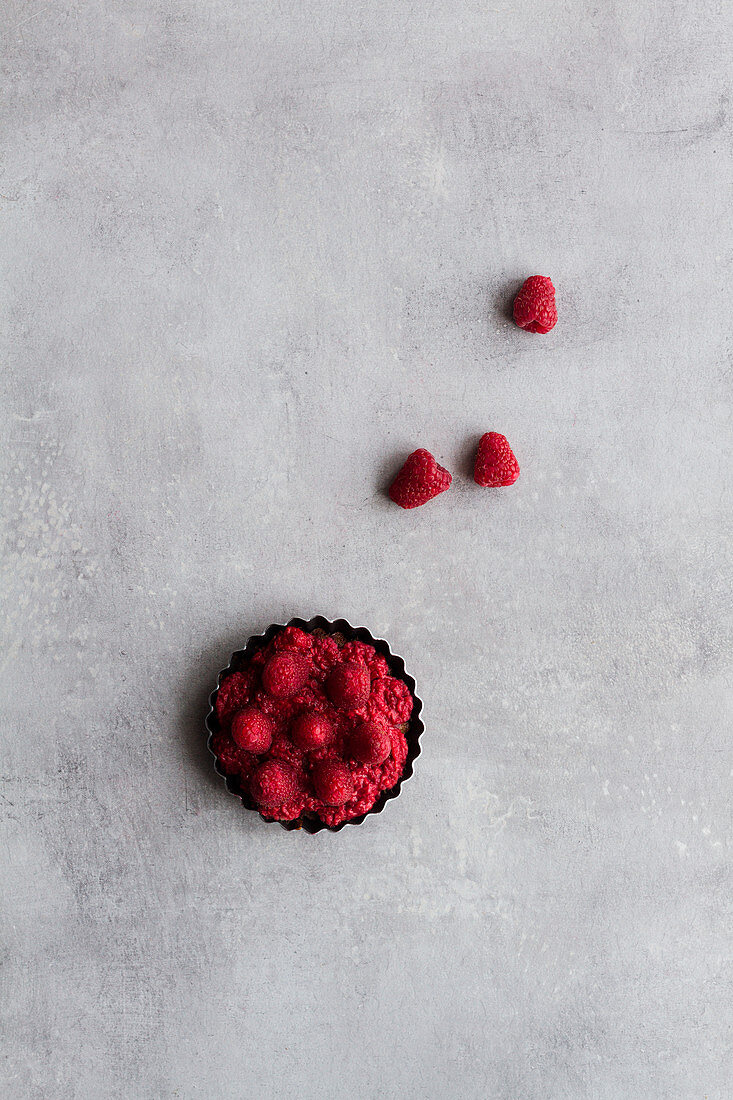 Top view of palatable pie with raspberry arranged on table