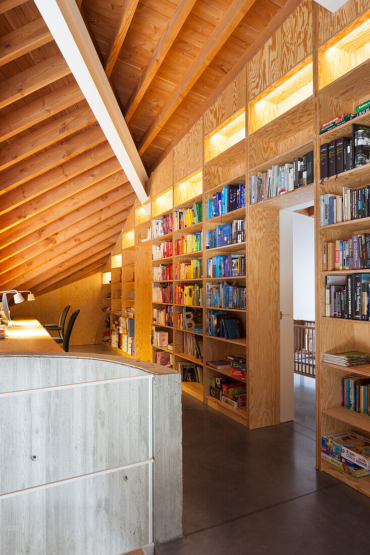 Bücherregal aus Holz reicht bis zur Dachschräge