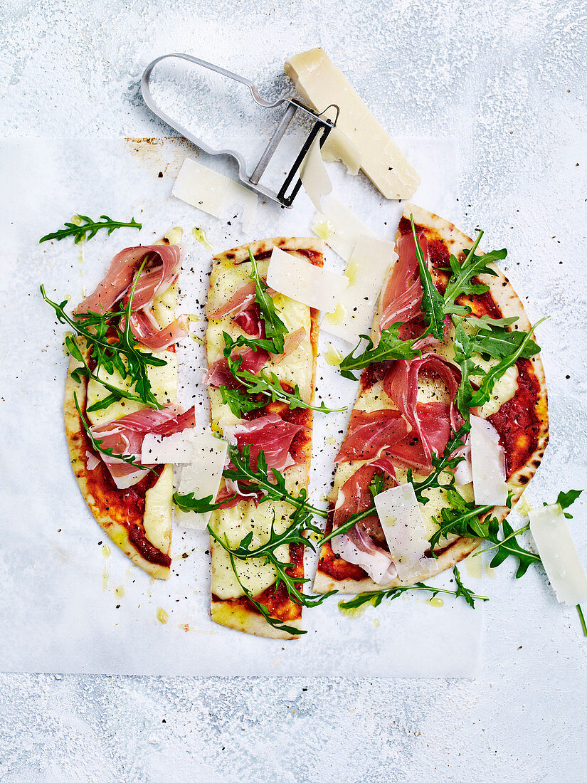 Pizza mit Schinken, Rucola und Parmesan