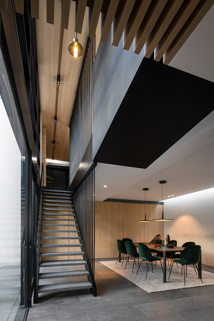 Dark green velvet chairs at long table in modern dining room