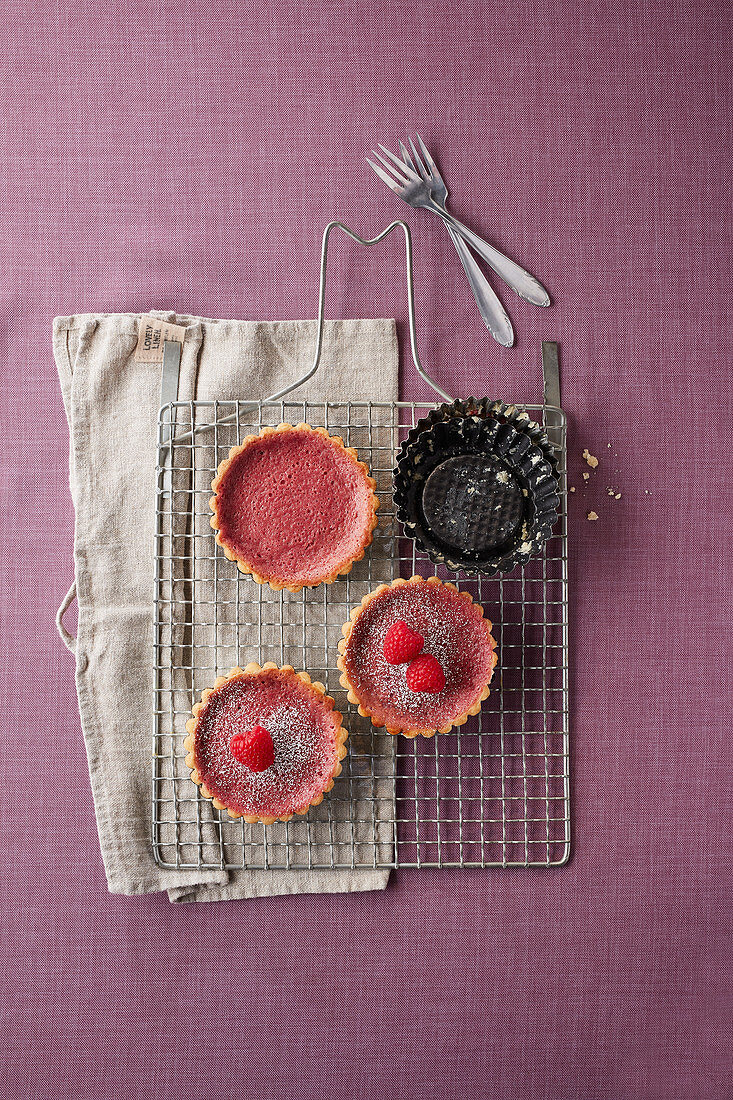Raspberry tartlets on a cooling rack