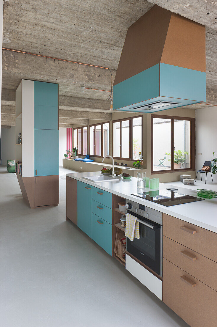 Modern kitchen with turquoise cabinet fronts and concrete ceiling