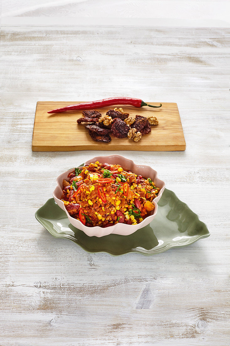 Chili con carne with minced nuts, corn and carrots