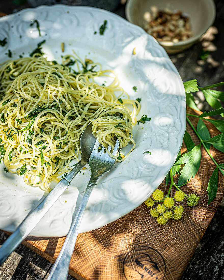 Spaghetti mit Liebstöckel-Pesto auf Tisch im Freien